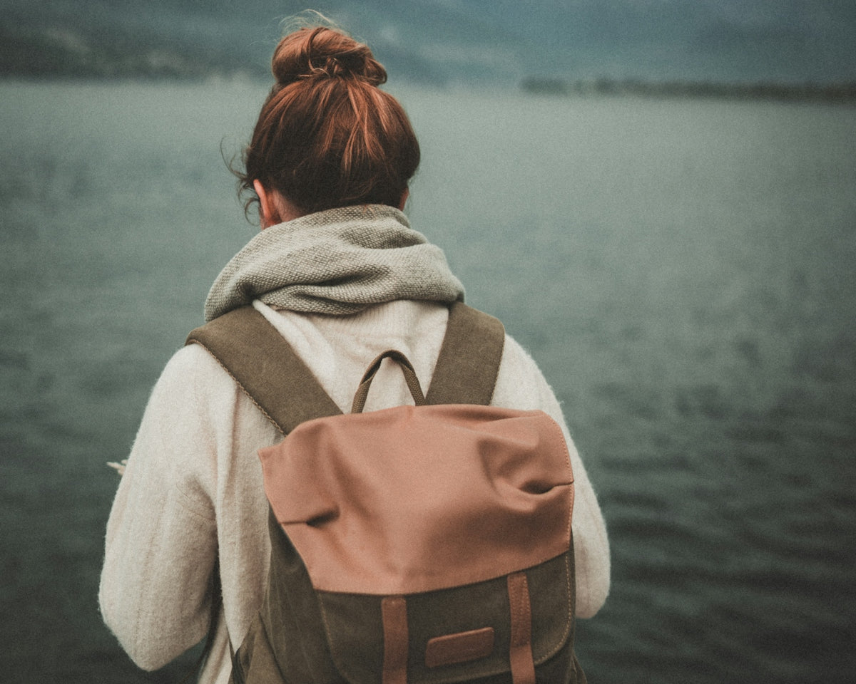 woman standing nearby calm body of water ]