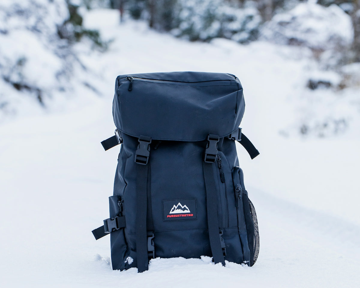 black backpack on snow covered ground