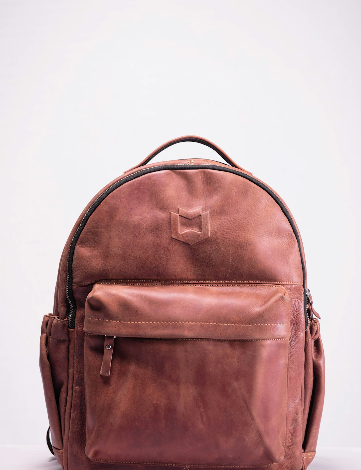 brown leather backpack on white surface