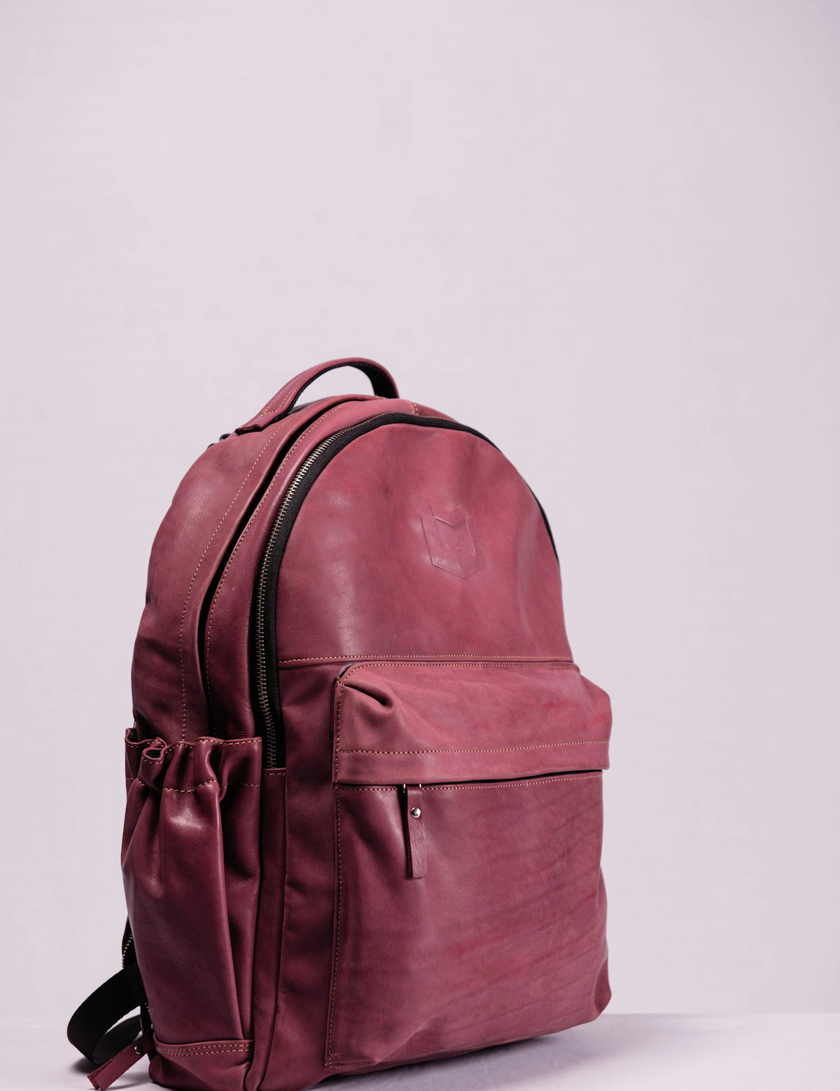 red leather backpack on white wall