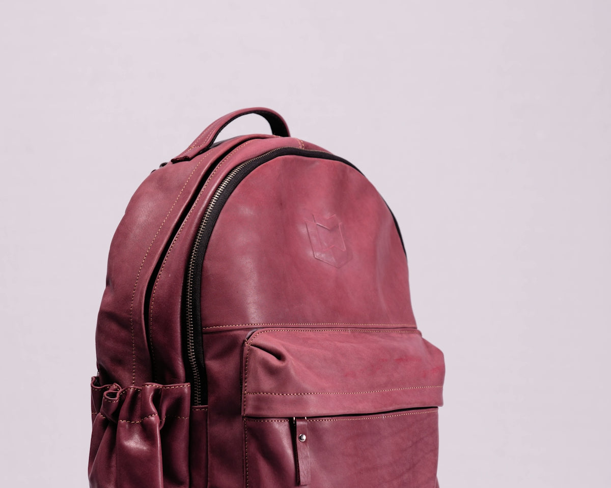 red leather backpack on white wall