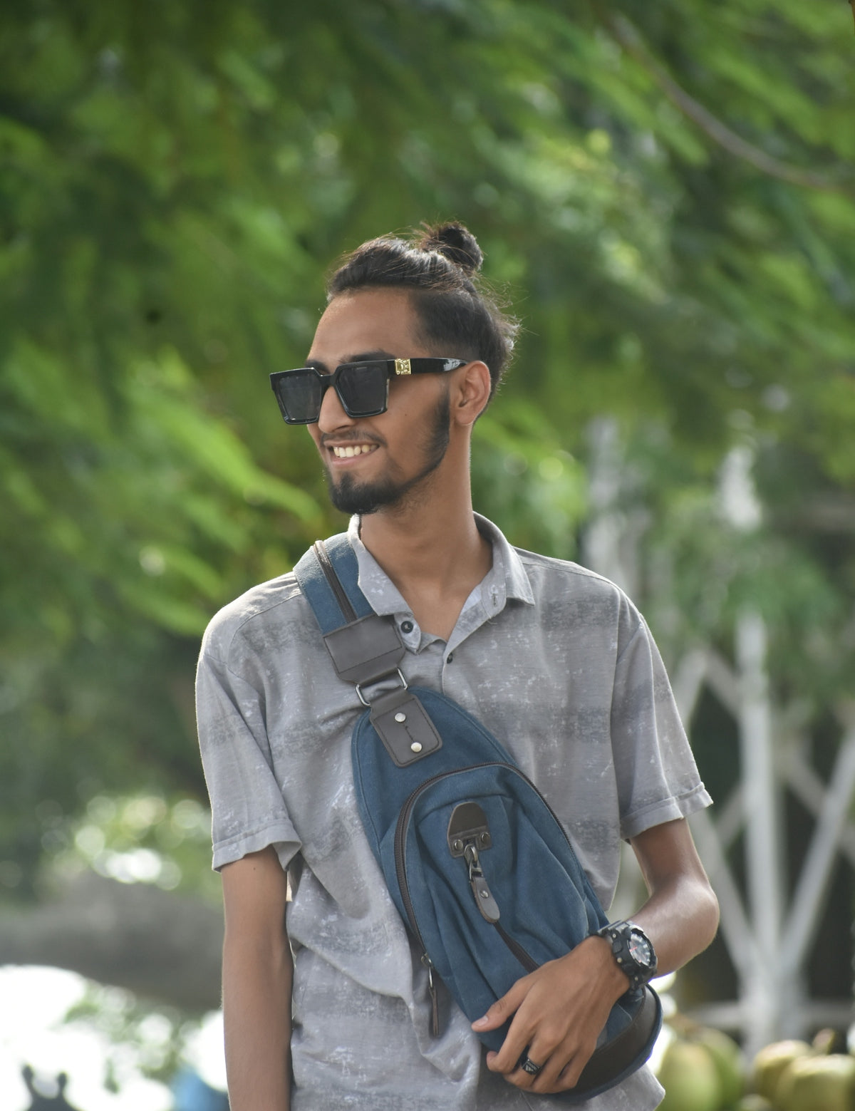 a man wearing sunglasses and carrying a blue bag