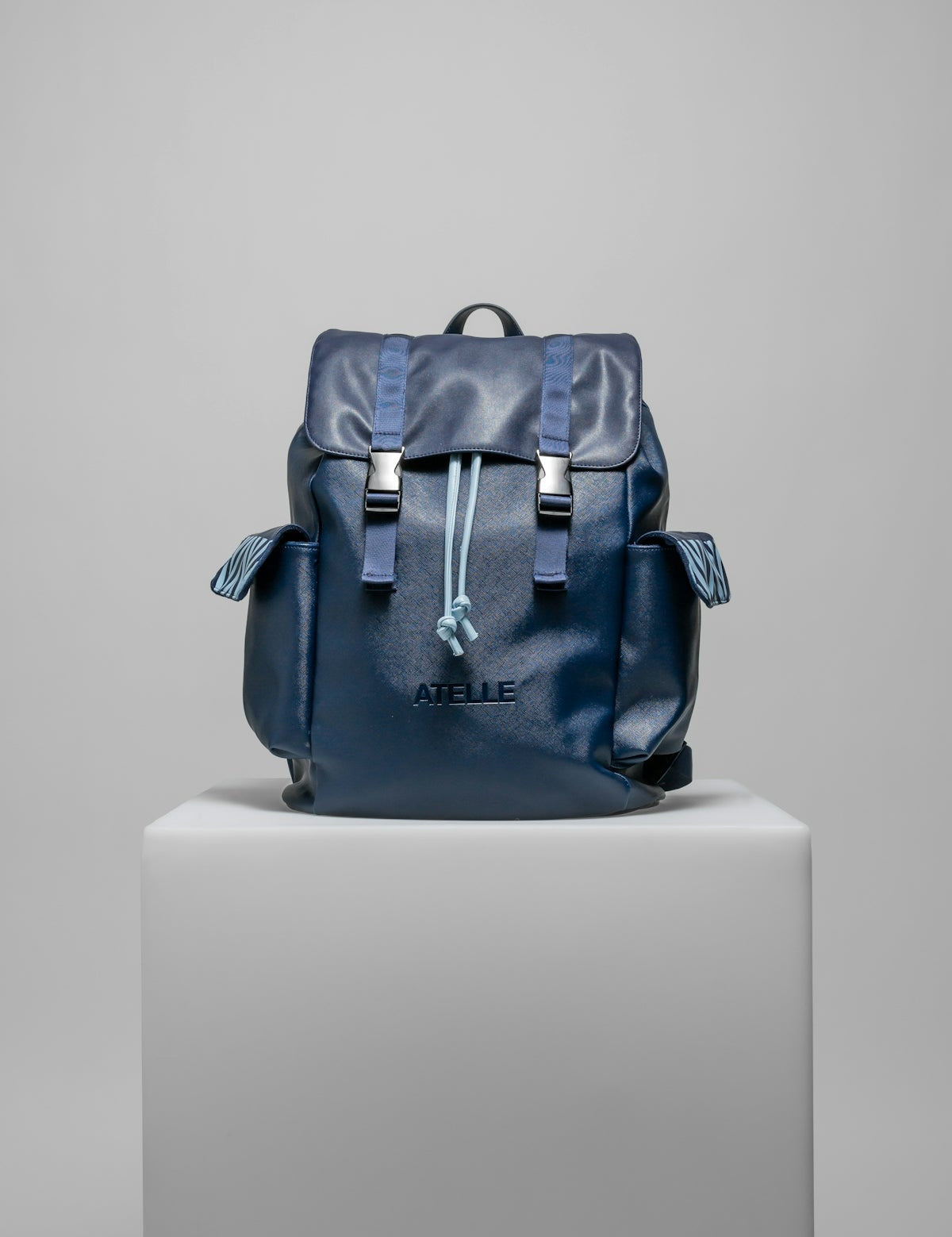 a blue backpack sitting on top of a white pedestal