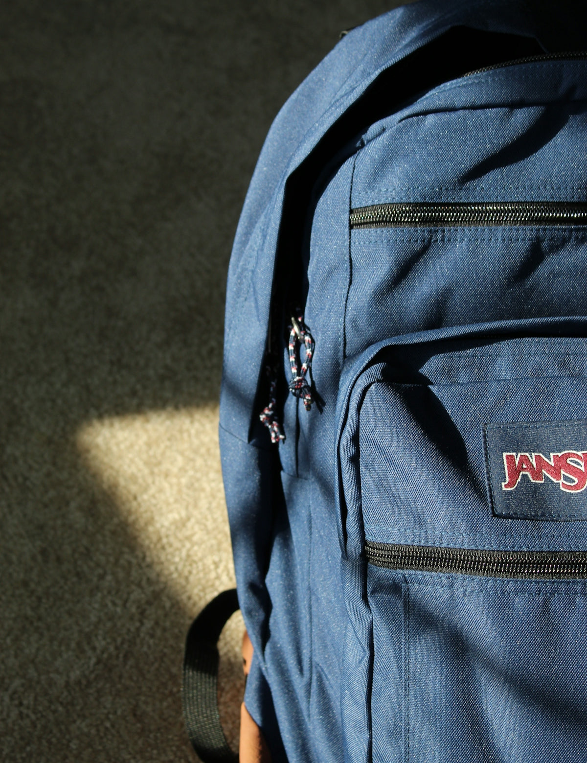 a blue jansport backpack sitting on the ground