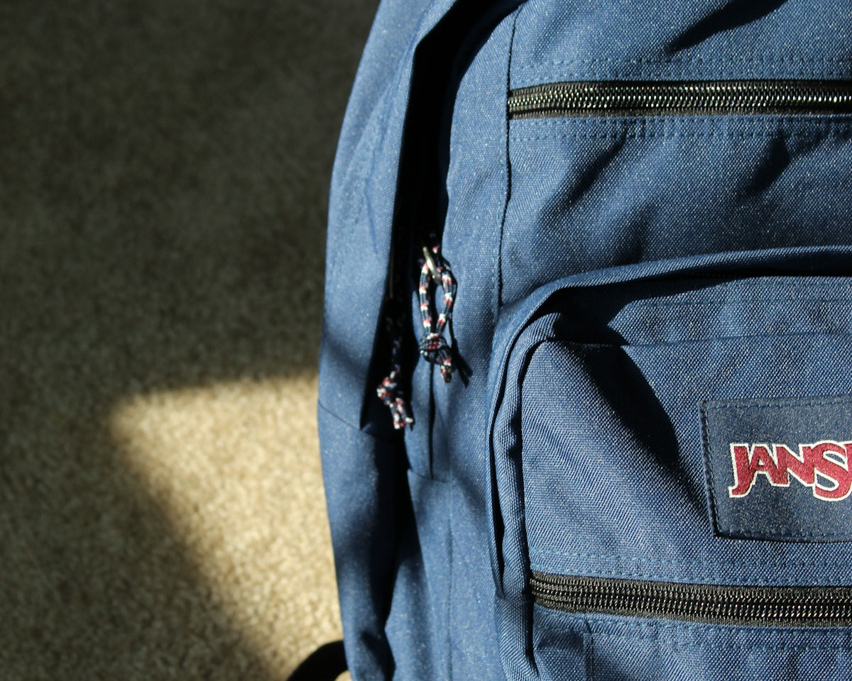 a blue jansport backpack sitting on the ground