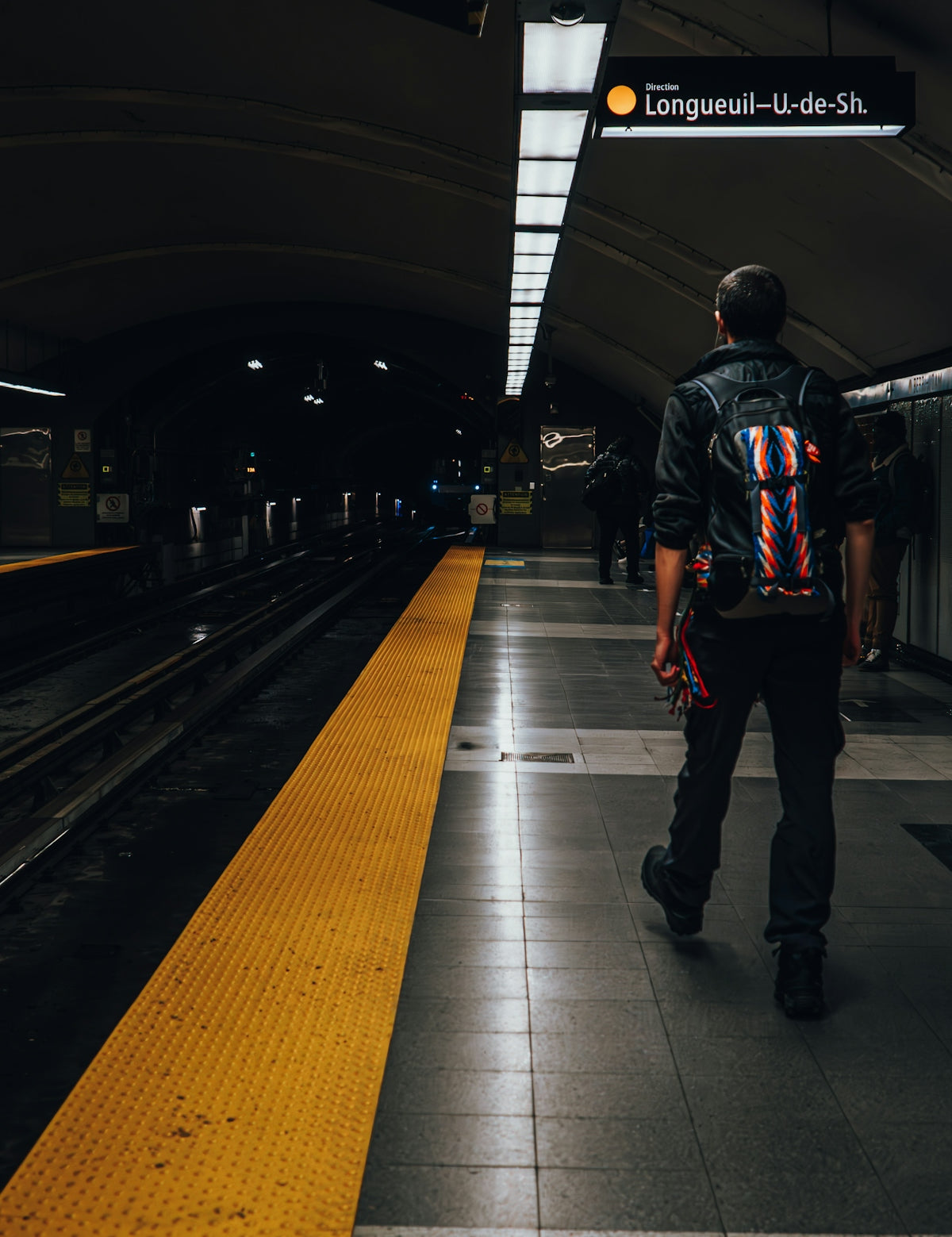 a man walking down a train station platform