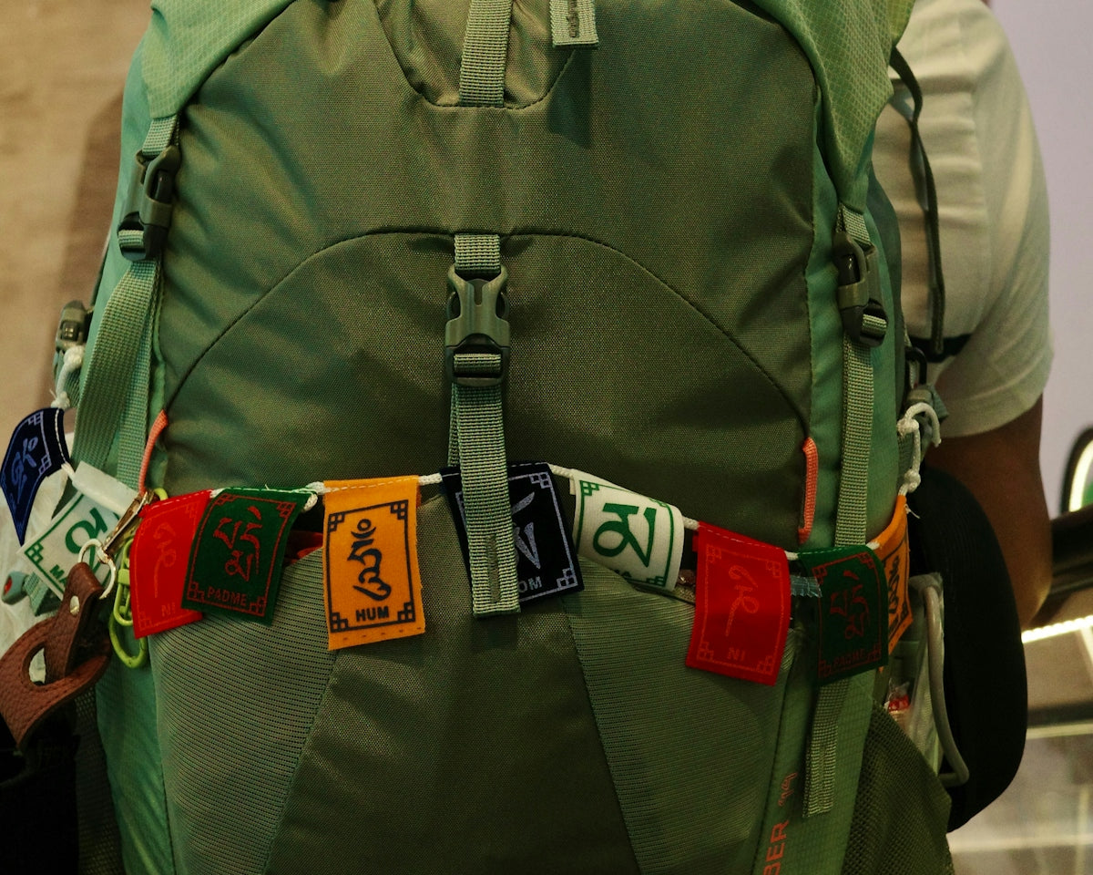 Green backpack with prayer flags attached