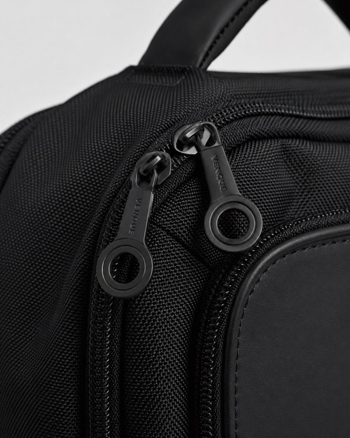 Close-up of VENQUE branded zipper pulls on the Envoy Business Pack