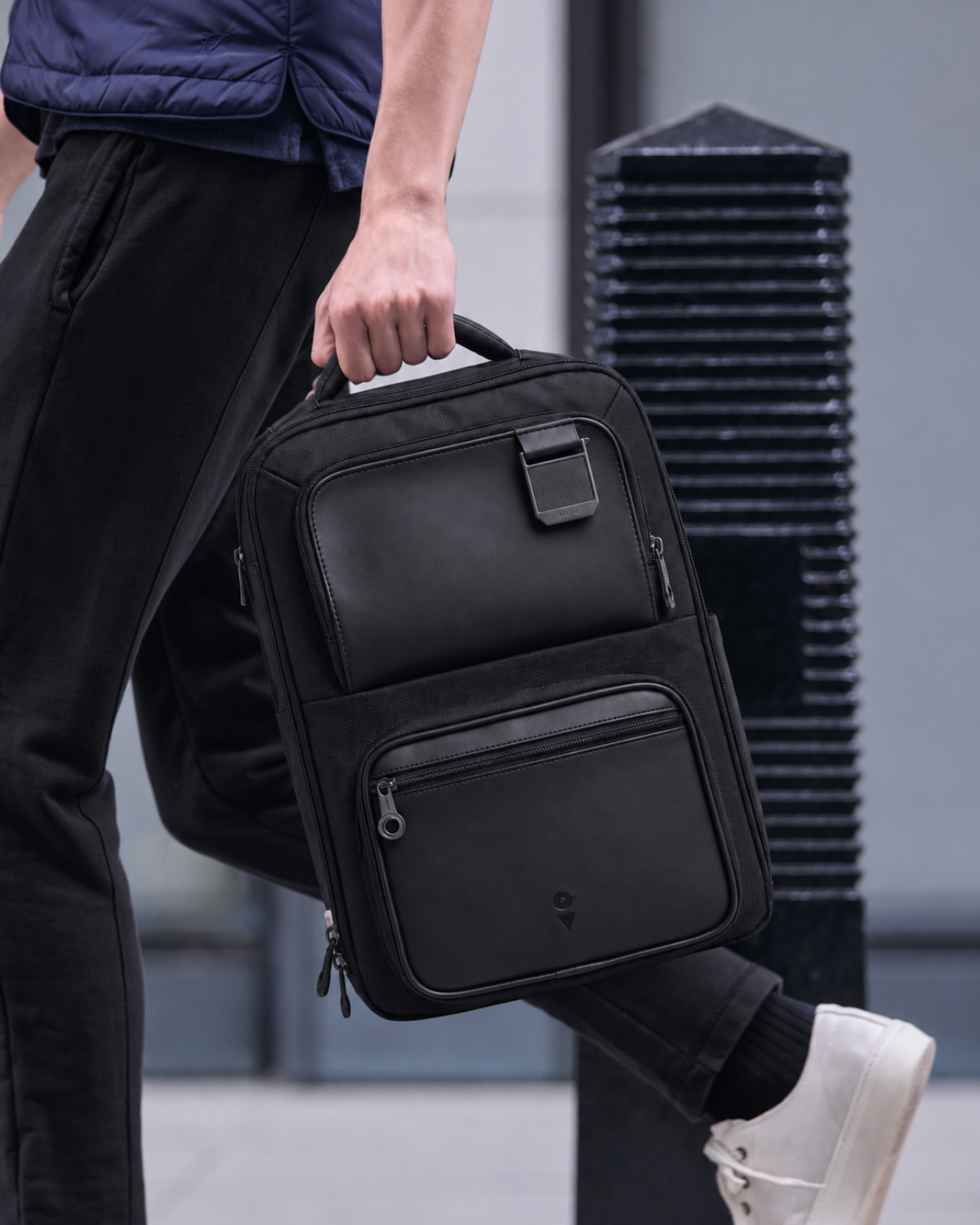 Man carrying the Envoy Business Pack by its top handle