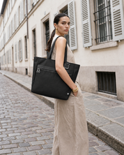 Woman carrying the Voya Executive Tote on a city street