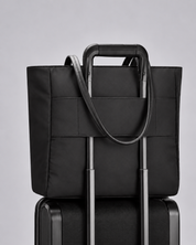 Voya Executive Tote on a suitcase handle using the luggage pass-through
